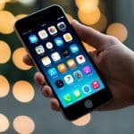 Uma mão segurando um smartphone com aplicativos dispostos em um padrão de grade na tela