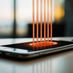 Um smartphone descansando em um carregador com ondas de calor visíveis subindo do dispositivo