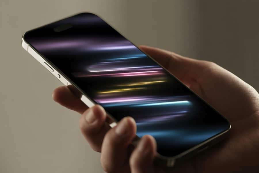 Tela de celular moderna piscando em close-up, segurada por uma mão com fundo desfocado.