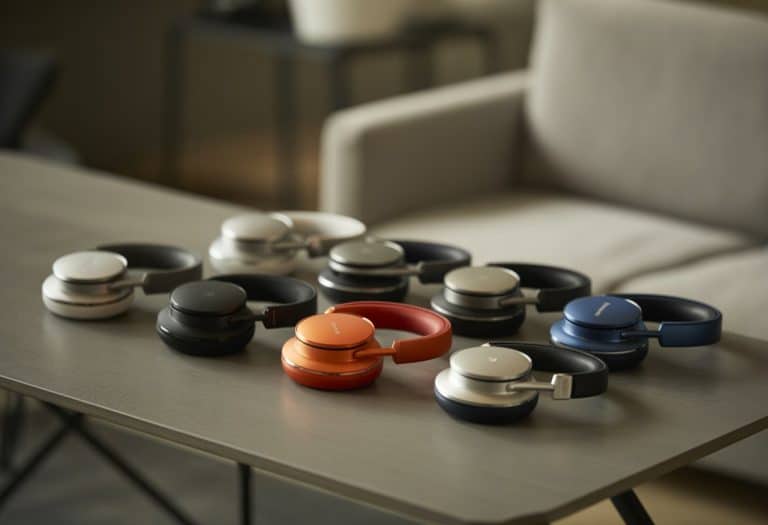 Diversos fones de ouvido de marcas renomadas organizados sobre uma mesa de madeira em um ambiente limpo e moderno.